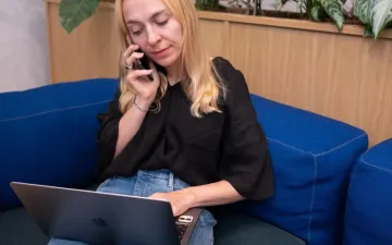 Sales professional working on a laptop and mobile phone